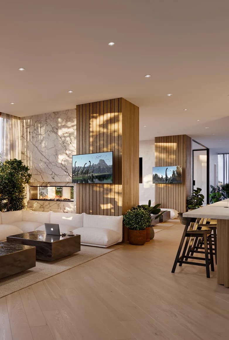 A lounge at Ironwood with a marble fireplace, white sofas and a bar counter